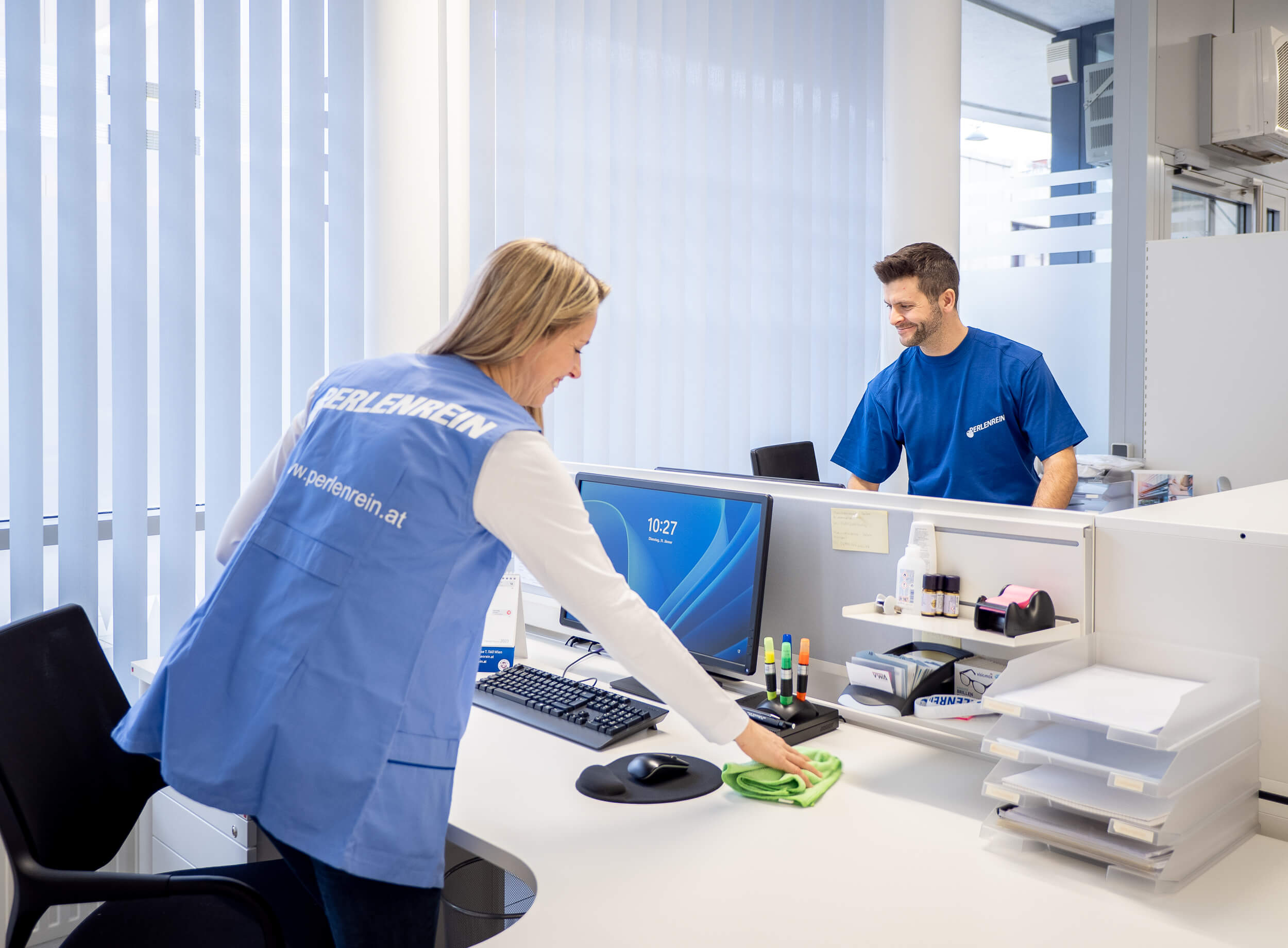 Professionelle Büro-Grundreinigung am Arbeitsplatz Perlenrein-Mitarbeiterin reinigt einen Büroarbeitsplatz im Rahmen einer professionellen Büro-Grundreinigung in Wien